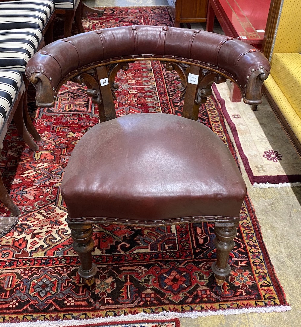 A Victorian oak and burgundy leather desk chair, width 66cm, depth 50cm, height 76cm